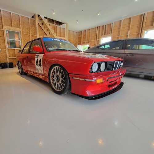 a red car sitting on top of an epoxy floor coating